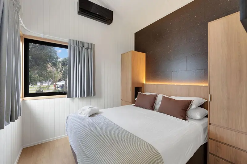 Une chambre lumineuse avec un grand lit et une fenêtre.