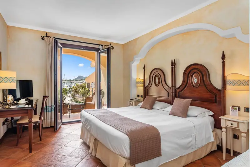 Chambre lumineuse avec un grand lit et une vue sur une terrasse.