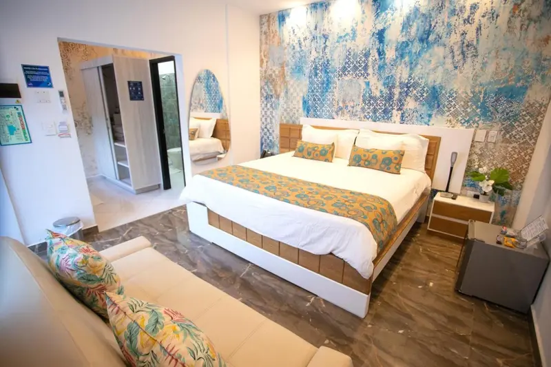 Une chambre lumineuse avec un grand lit et un canapé.