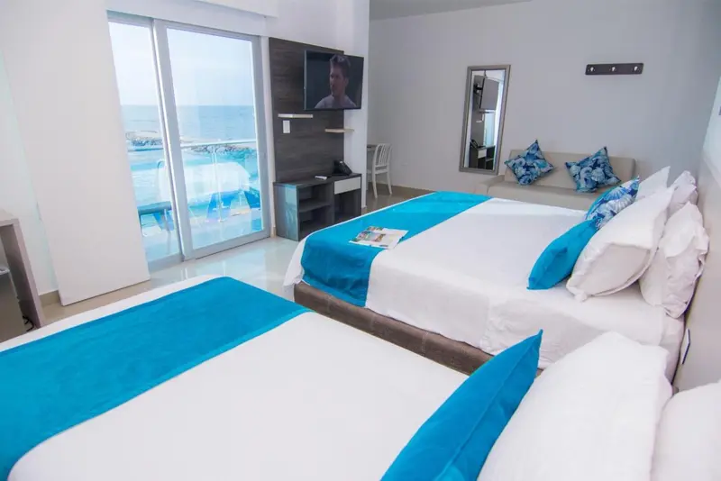 Chambre lumineuse avec lits jumeaux et vue sur la mer.
