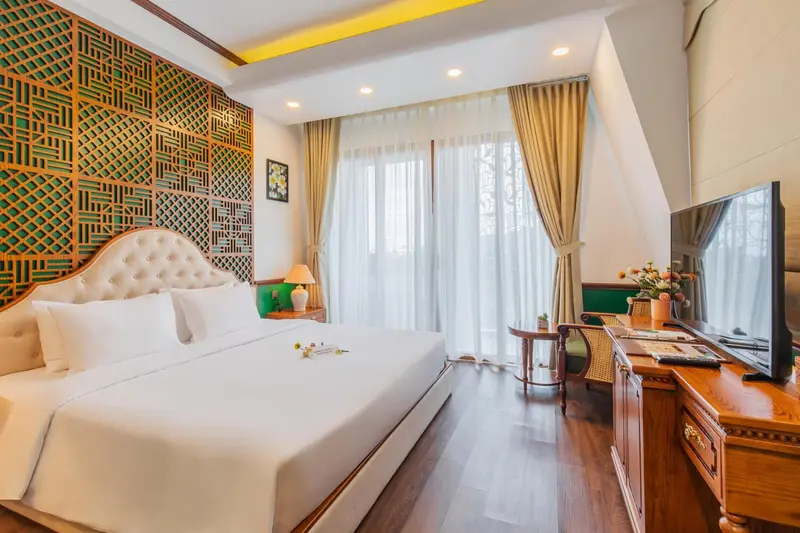 Une chambre lumineuse avec un grand lit et un coin salon.