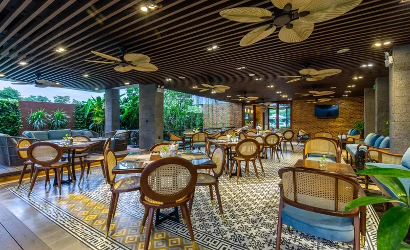 Une salle à manger intérieure avec des tables et des chaises en rotin.