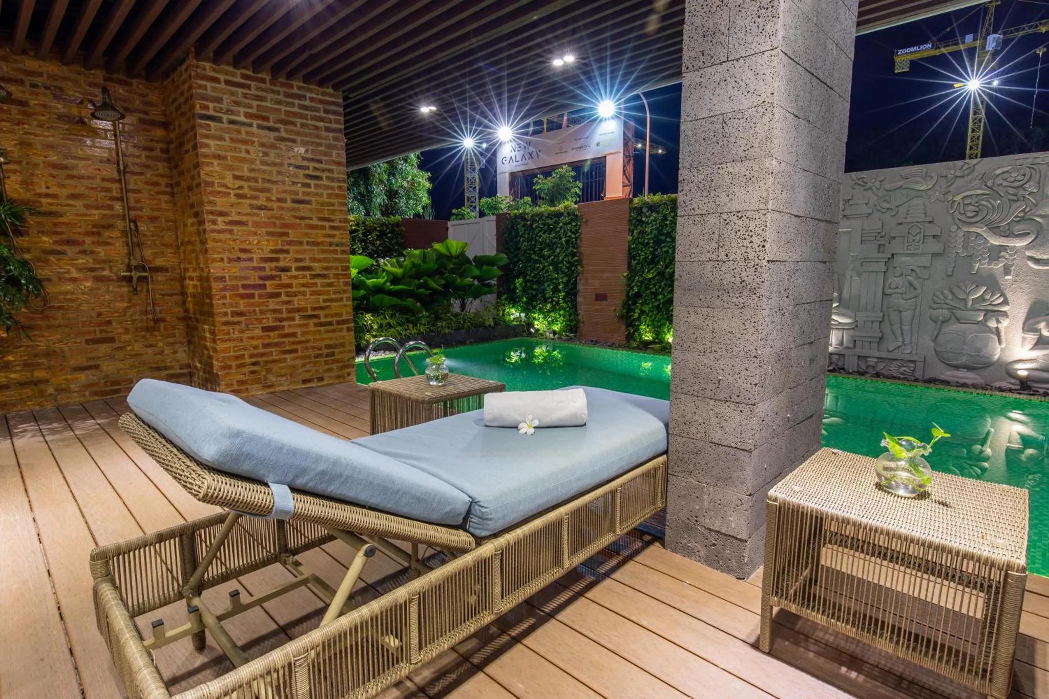 Espace de détente extérieur avec transats et petite piscine illuminée.