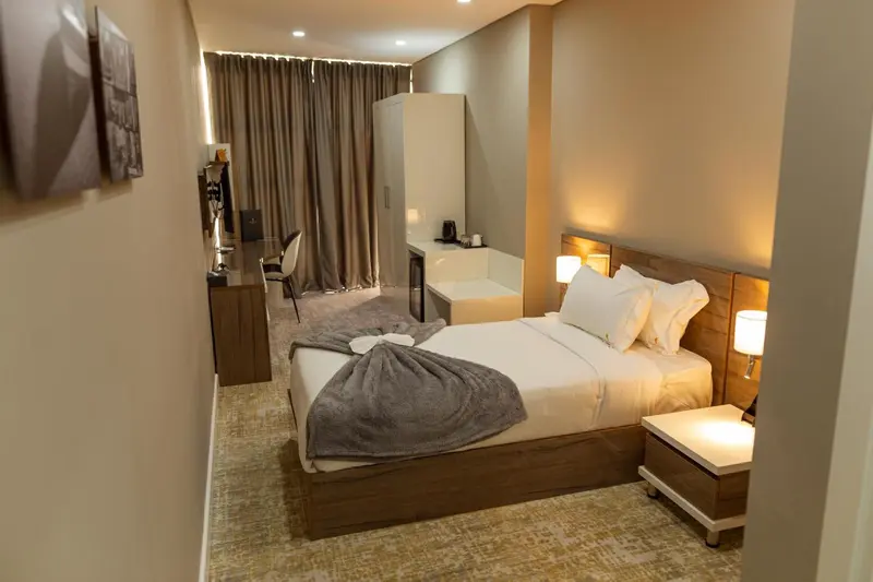 Une chambre lumineuse avec un grand lit et un espace détente.