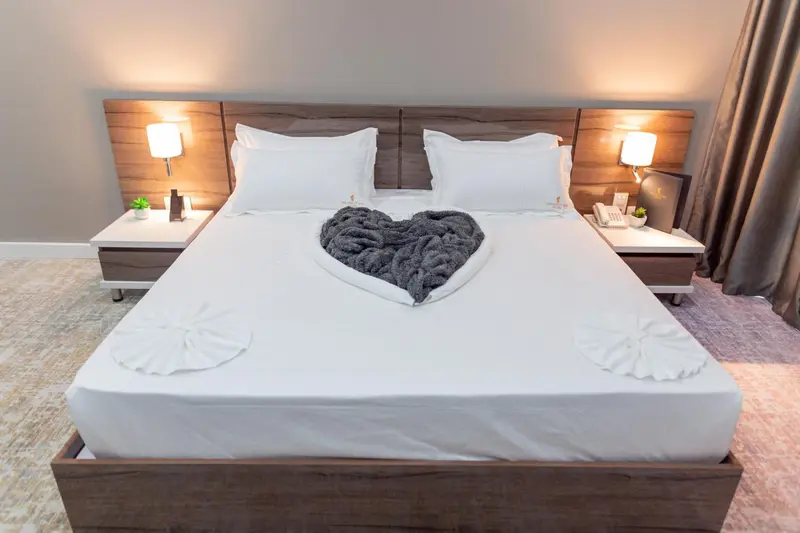 Un lit double est soigneusement fait dans une chambre lumineuse.