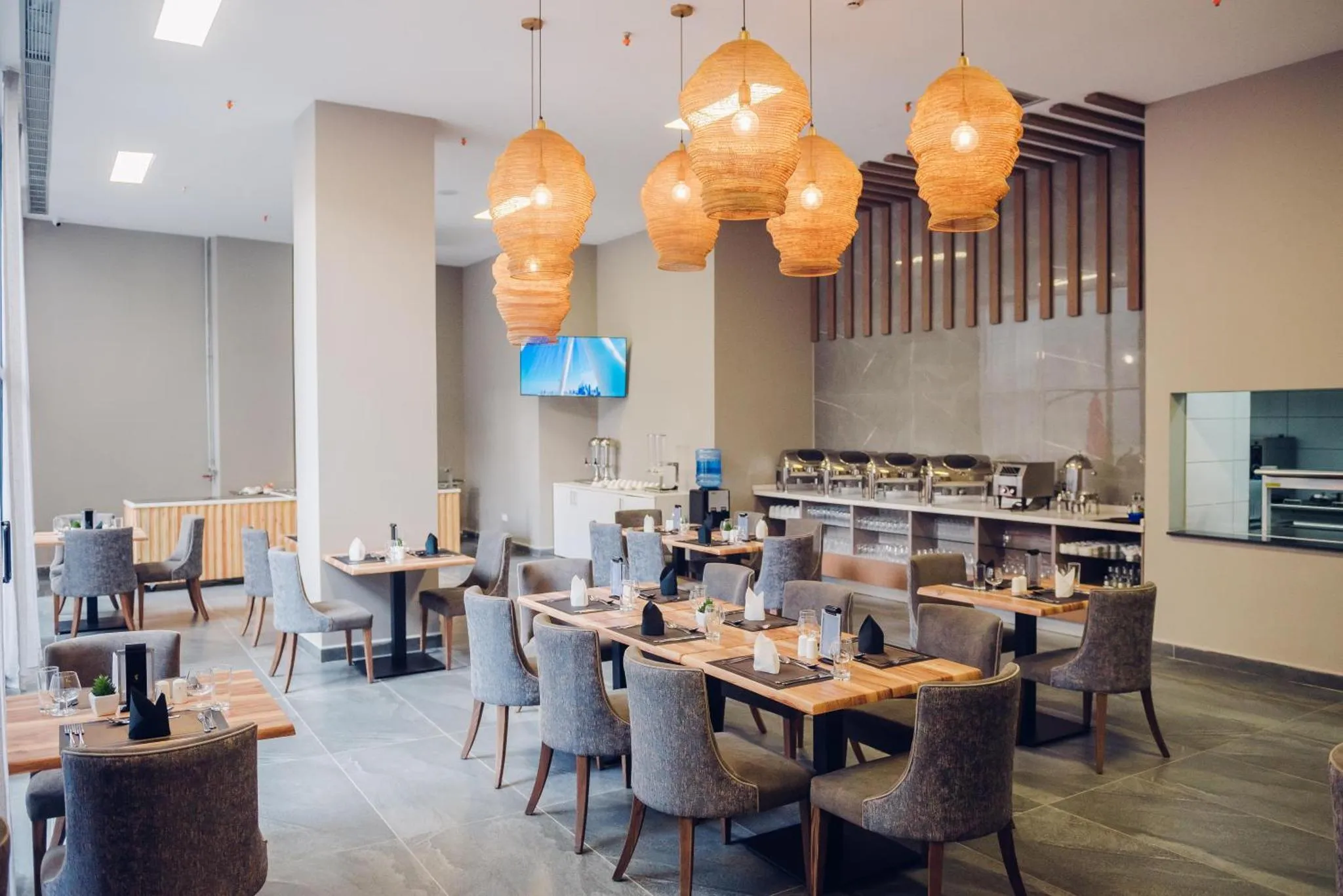 Une salle lumineuse avec des tables dressées pour un repas.