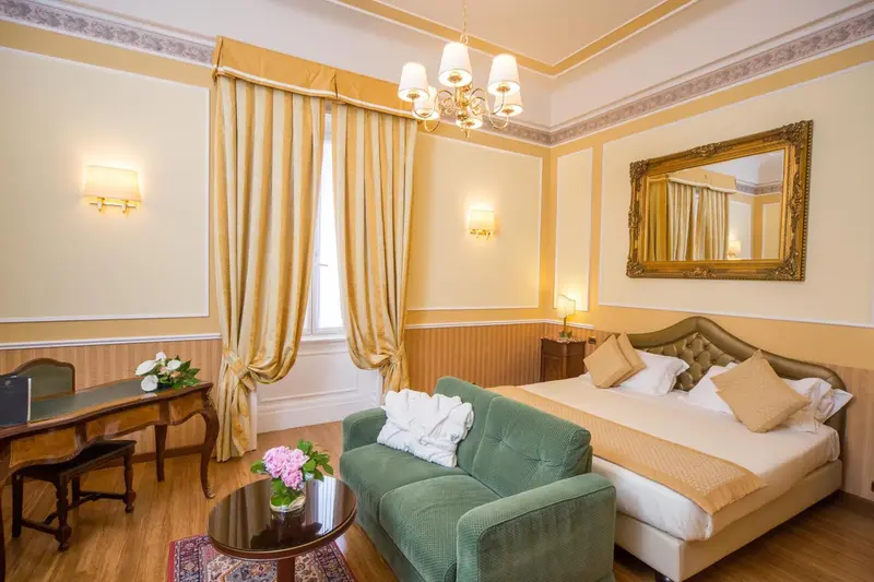 Une chambre lumineuse avec un lit et un petit canapé.