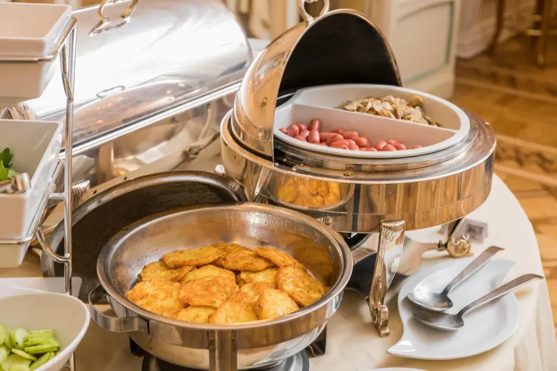 Présentation de plats chauds sur un buffet.