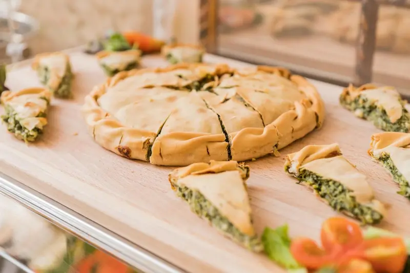 Assortiment de tartes salées présentées sur un buffet.