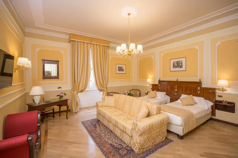 Chambre lumineuse avec canapé et décoration florale.