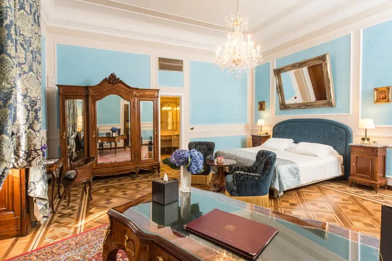 Une chambre lumineuse avec un grand lit et un mobilier en bois sculpté.