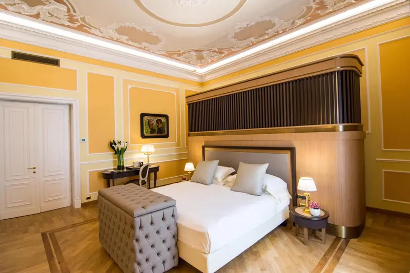 Chambre à coucher lumineuse avec un grand lit et une décoration classique.