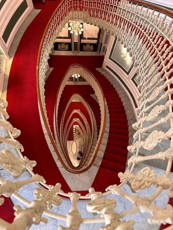 Escalier en colimaçon rouge et blanc orné de motifs floraux.