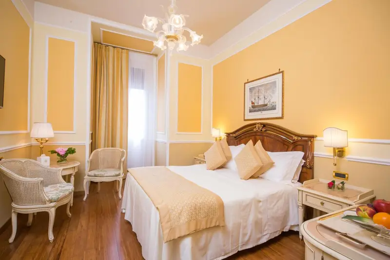 Une chambre lumineuse avec un lit double et un fauteuil.