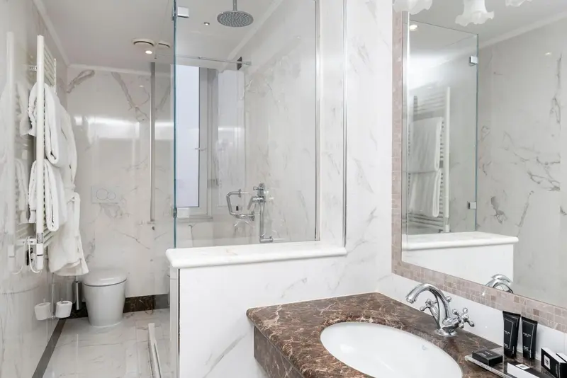 Une salle de bain moderne avec douche à l'italienne et lavabo en marbre.