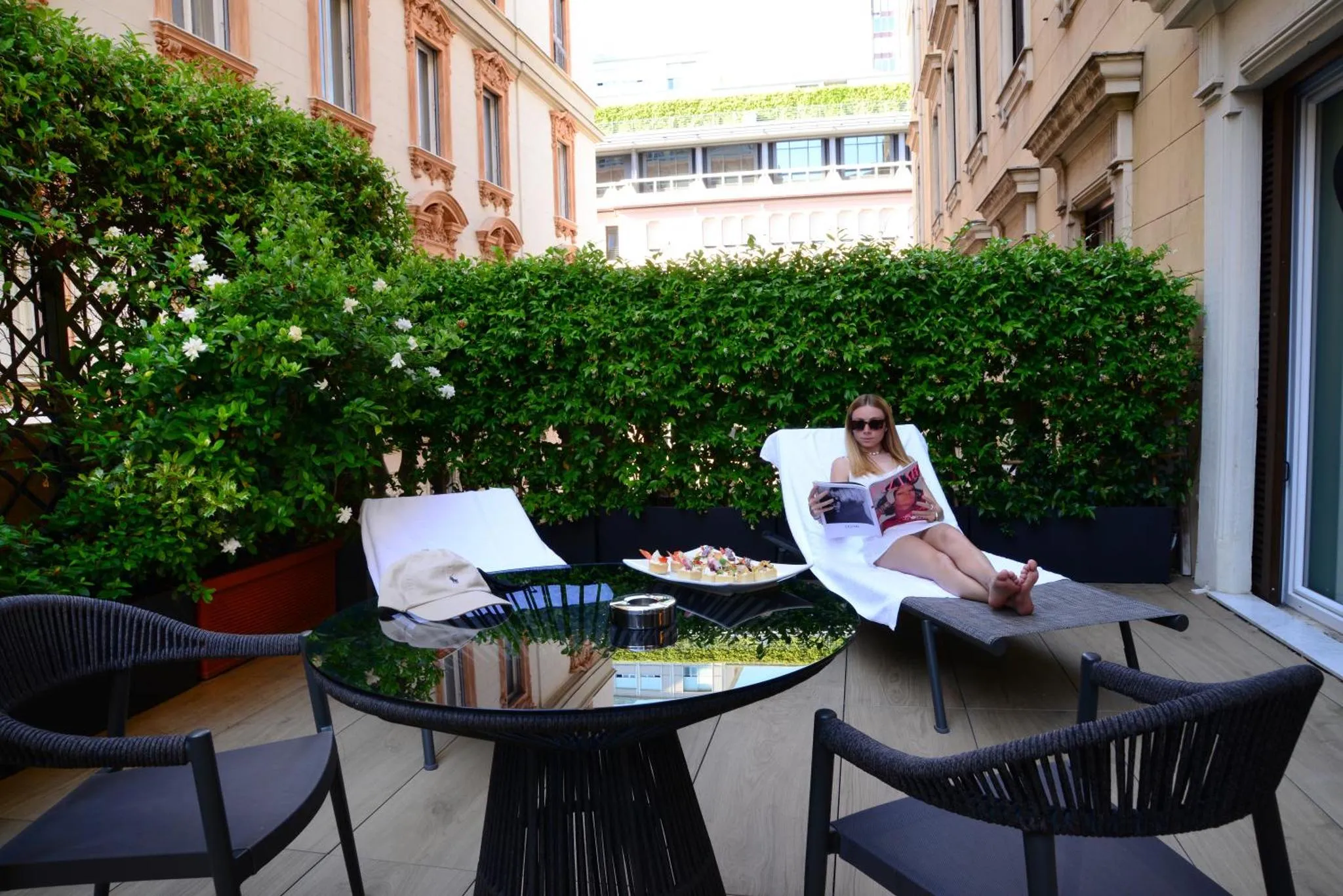 Une personne se détend sur une terrasse aménagée avec des transats et une table.