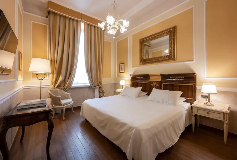 Une chambre lumineuse avec un lit à baldaquin et des rideaux dorés.