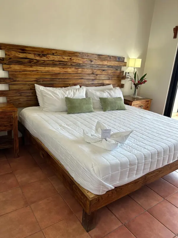 Un lit double avec une tête de lit en bois et une décoration florale.