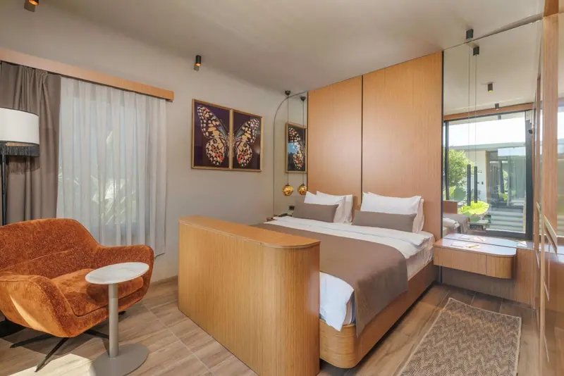 Une chambre moderne avec un grand lit et un fauteuil.
