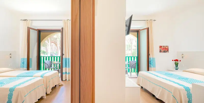 Une chambre lumineuse avec deux lits simples et un balcon.