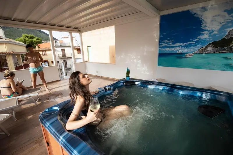 Des personnes se détendent dans un jacuzzi intérieur avec vue sur un paysage côtier.
