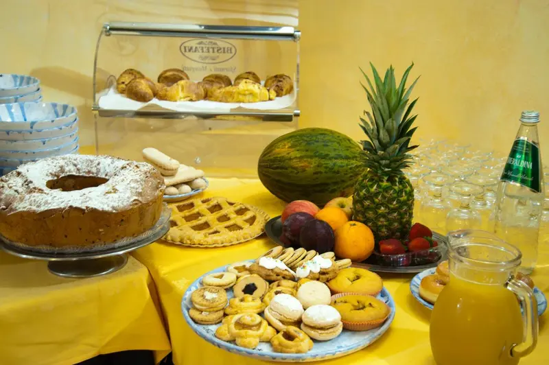 Une table garnie de pâtisseries, de fruits frais et de boissons.