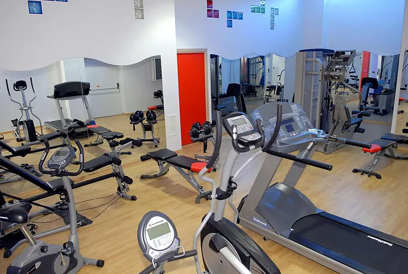 Une salle de sport lumineuse avec divers équipements de fitness.