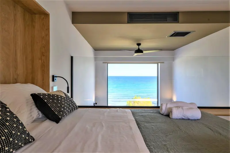 Une chambre lumineuse avec un grand lit donnant sur la mer.