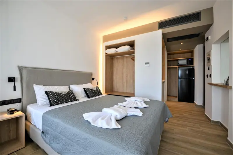 Une chambre lumineuse avec un grand lit et un espace rangement intégré.