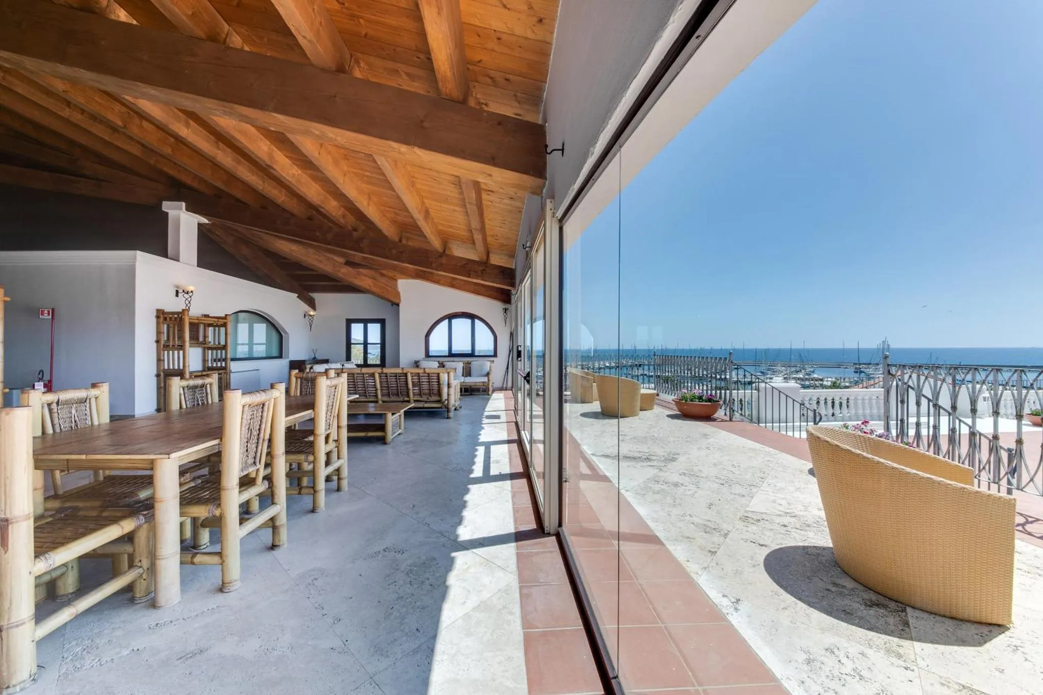 Une salle à manger lumineuse s'ouvre sur une terrasse avec vue sur la mer.