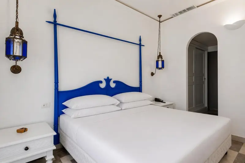 Une chambre lumineuse avec un grand lit à baldaquin bleu.