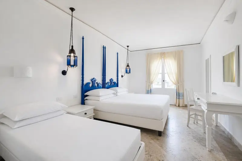 Une chambre lumineuse avec deux lits et une décoration sobre.