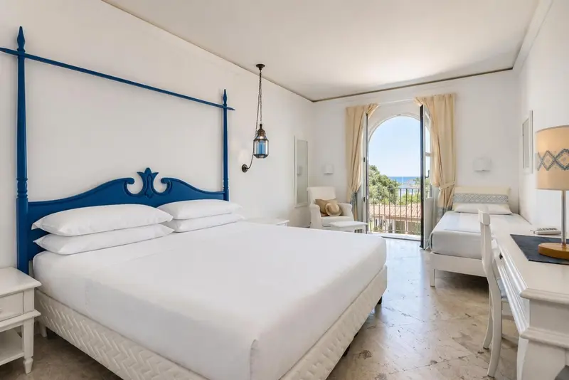 Une chambre lumineuse avec un grand lit et un bureau.
