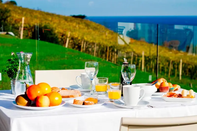 Une table est dressée avec un petit-déjeuner face à une vue sur la mer.
