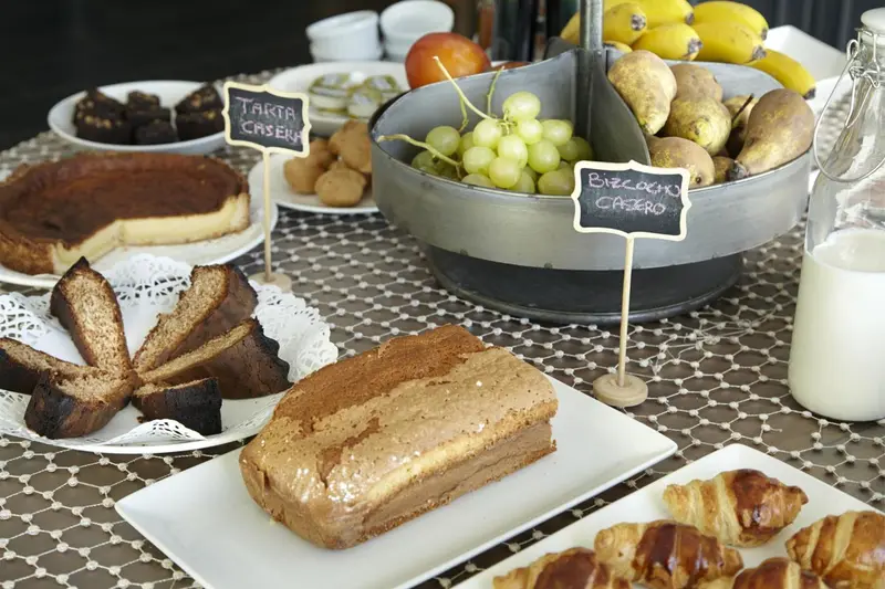 Une table basse présente une variété de pâtisseries et de fruits frais.