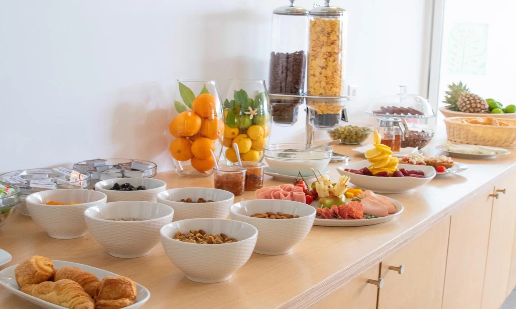 Un buffet propose des céréales, des fruits frais et de la pâtisserie.