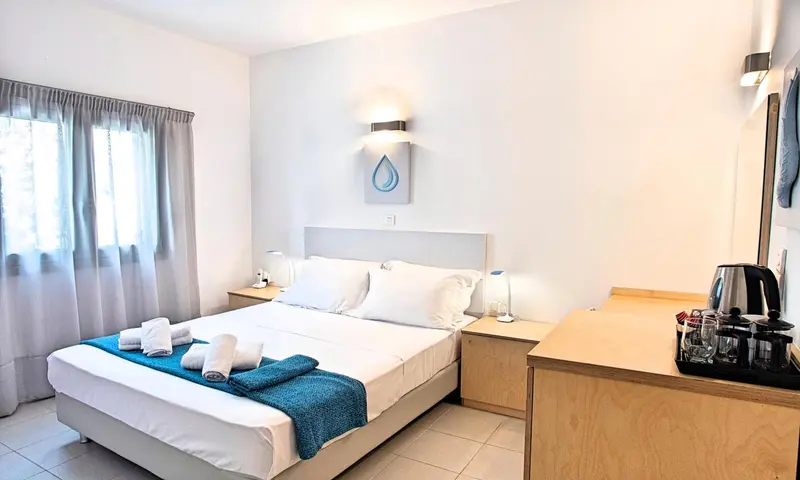 Une chambre lumineuse avec un grand lit et une table de chevet.