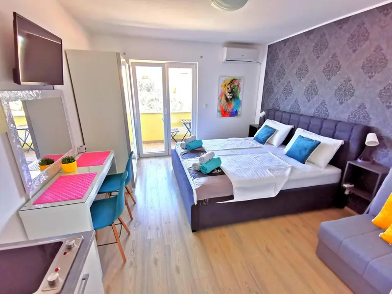 Une chambre lumineuse avec un lit double et un coin bureau.