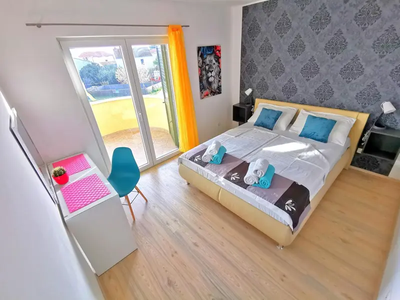 Une chambre lumineuse avec un grand lit et un accès à une terrasse.
