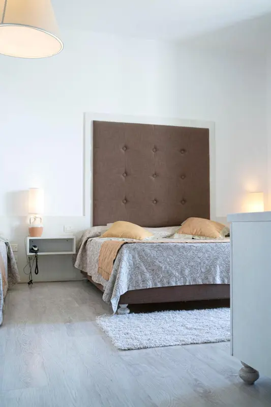 Une chambre lumineuse avec un grand lit et une décoration sobre.