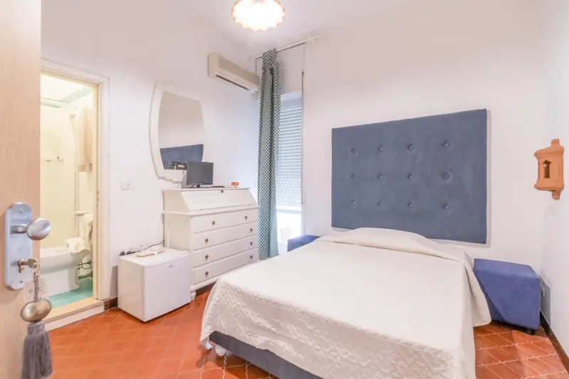 Une chambre lumineuse avec un grand lit et un accès à une salle de bain.