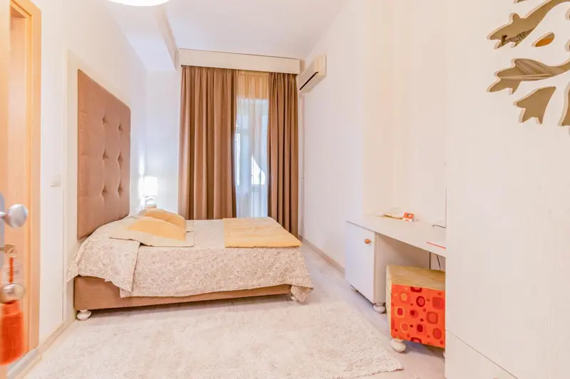 Une chambre lumineuse avec un grand lit et un bureau.