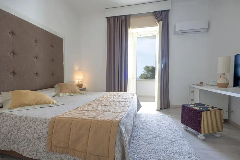 Une chambre lumineuse avec un grand lit et un accès à une terrasse.