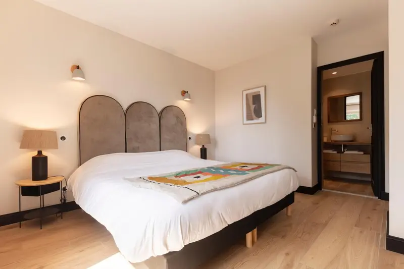 Une chambre lumineuse avec un grand lit et une décoration soignée.