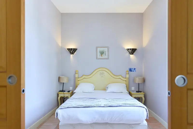 Une chambre lumineuse avec un lit double et des tables de chevet.
