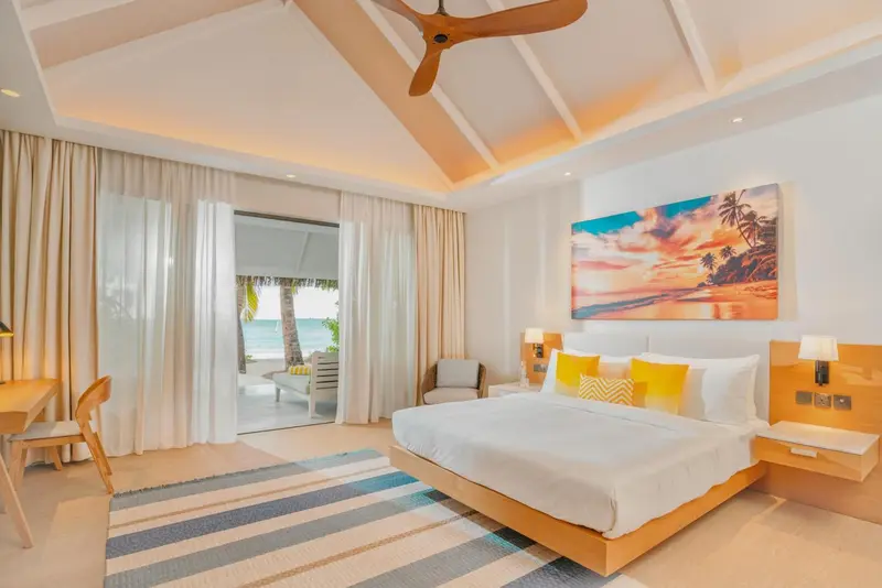 Une chambre lumineuse avec un lit king-size et vue sur la mer.