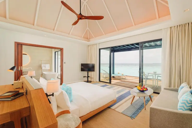 Une chambre lumineuse avec un lit confortable et un accès direct à une terrasse sur pilotis.
