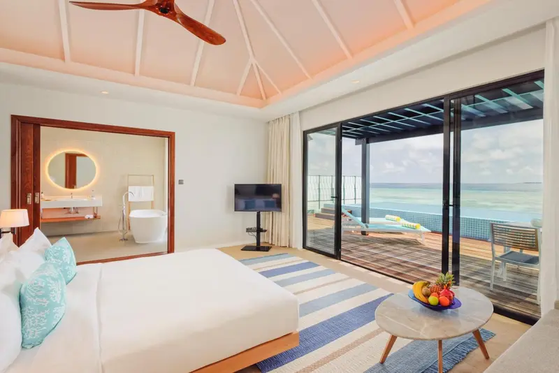 Chambre lumineuse avec un lit king-size et une vue sur l'océan.