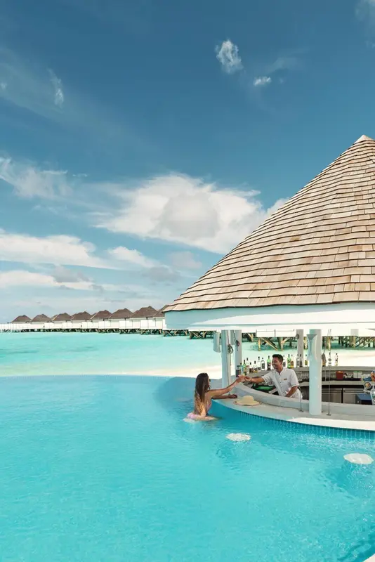 Un bar en bord de piscine avec des clients.