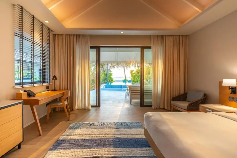 Une chambre lumineuse s'ouvre sur une terrasse avec vue sur l'océan.